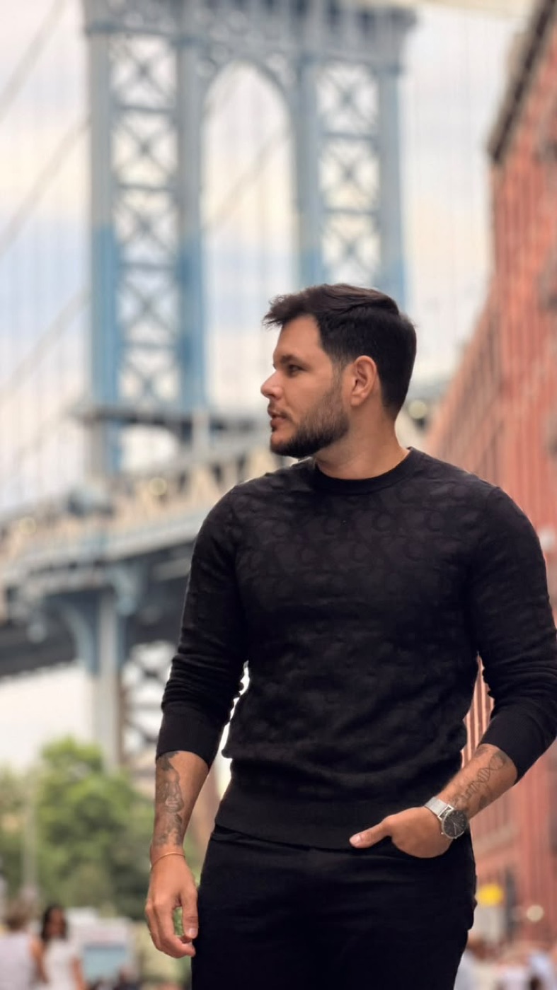 Sóstenes Costa Paiva em Brooklyn, com a Manhattan Bridge ao fundo